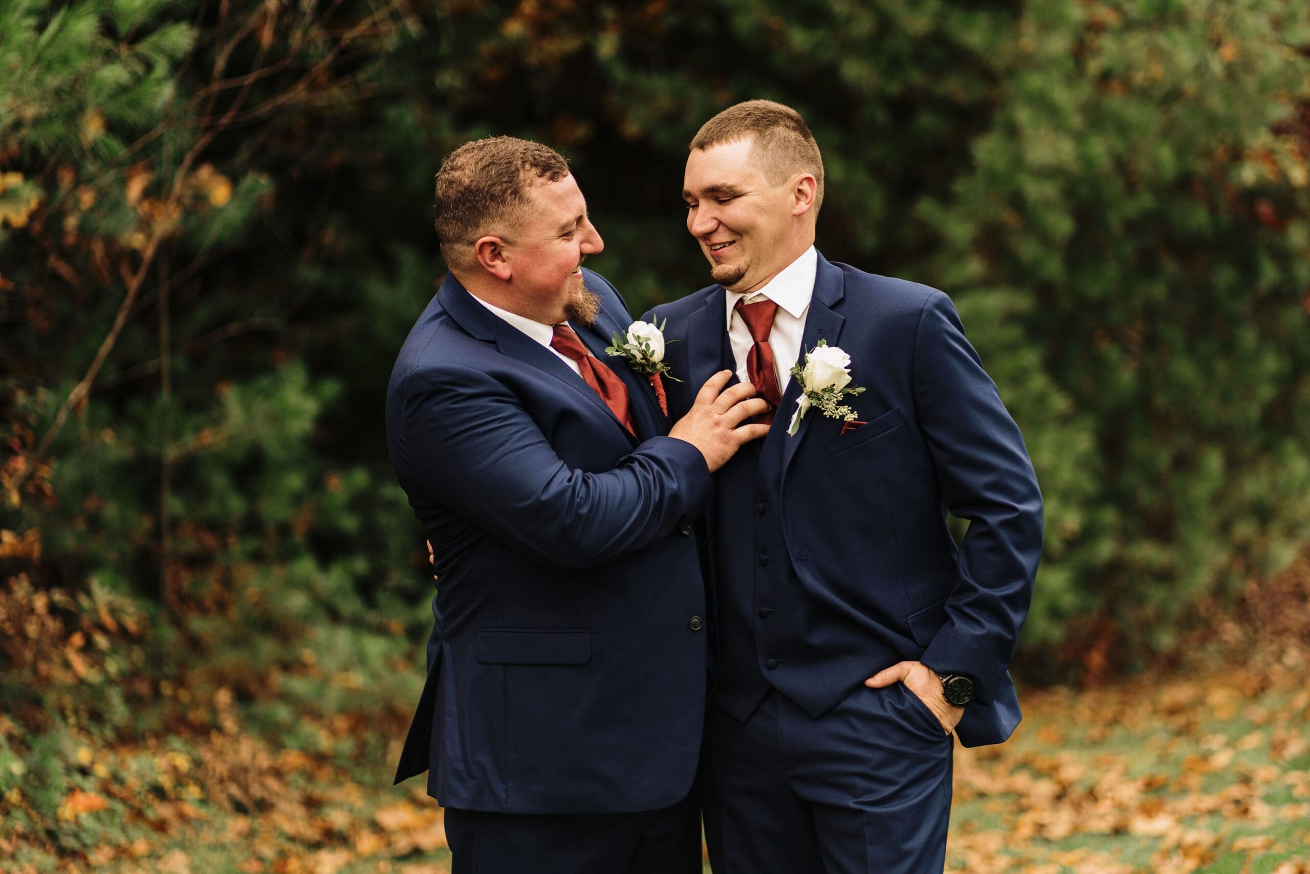 Groom and groomsman laughing together