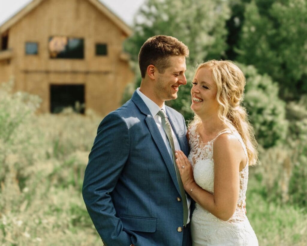 Bride and Groom Smiling With Venue as Backdrop