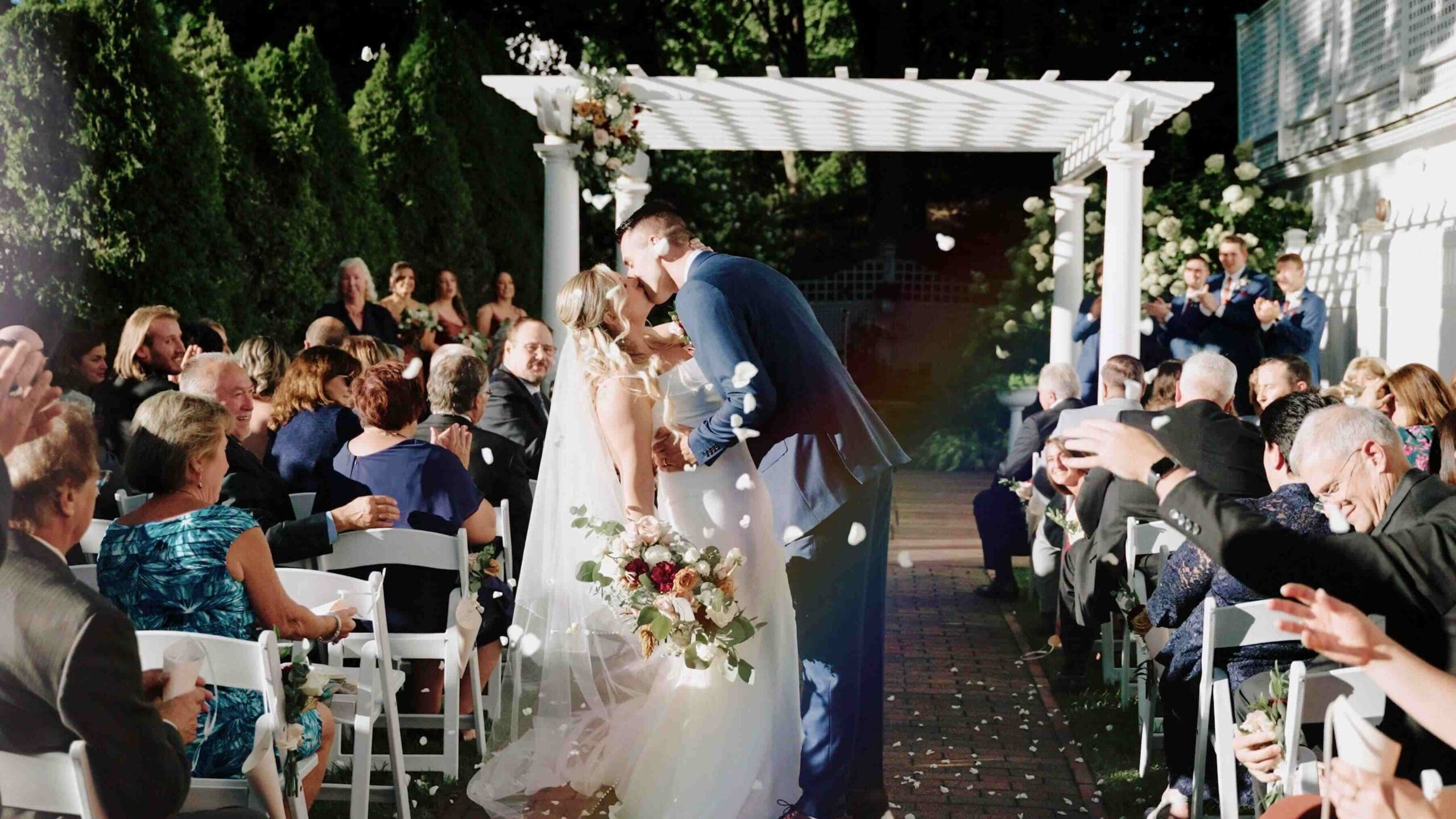 Couple Kissing In The Aisle With Flowers Outdoor Wedding