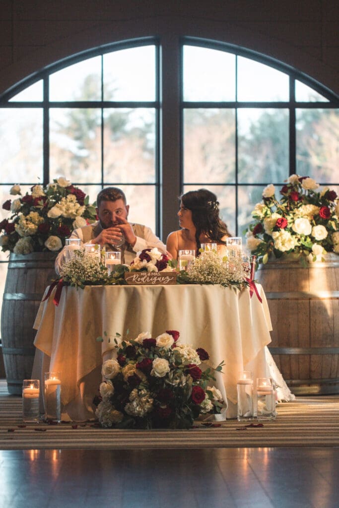 Couple Sitting In A Wedding Ceremony With Floral Decor
