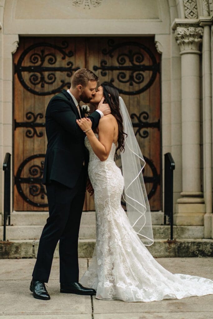 Bride and Groom Kissing With Wooden Backdrop