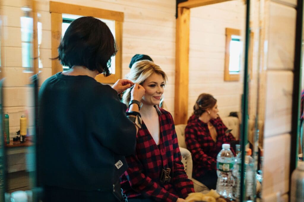 Hair and makeup artist styling a bride for her wedding