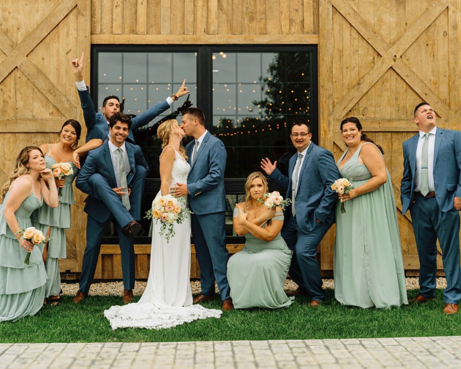 Bridal Party Posing With The Wedding Venue As Backdrop