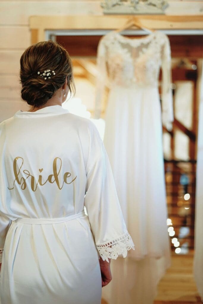 Bride Looking At Her Wedding Gown Hanging