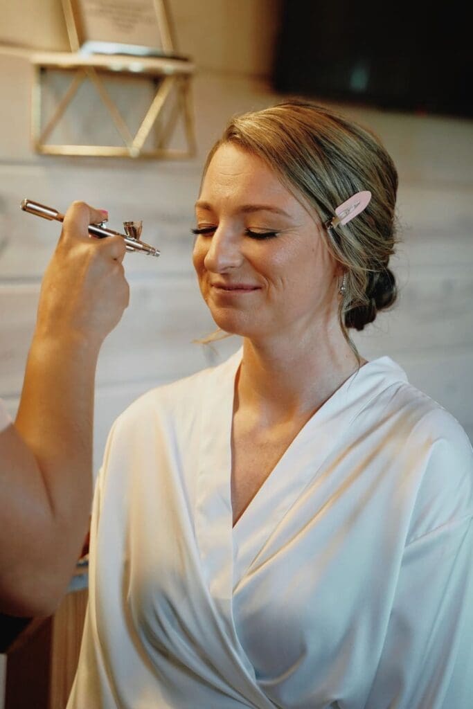 Makeup Artist Applying Airbrush on A Bride